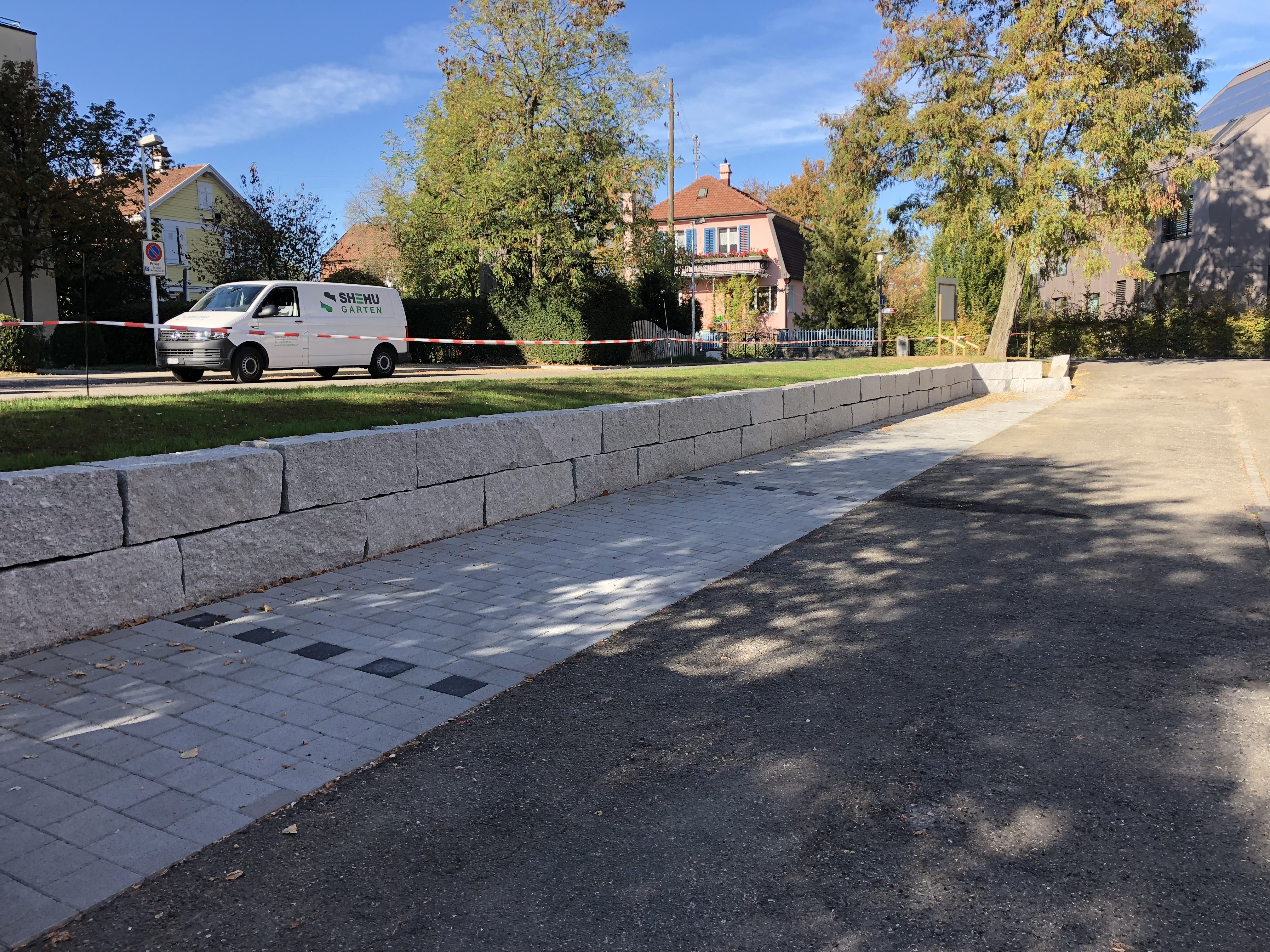 Öffentliche Granitmauer mit Pflasterbelag im Bau