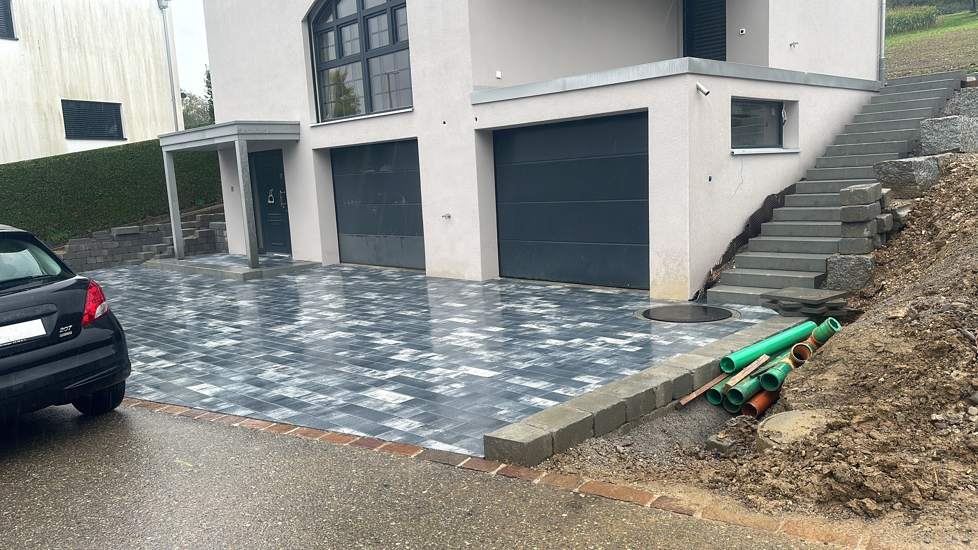 Zweifarbige Pflasterstein-Einfahrt vor Doppelgarage