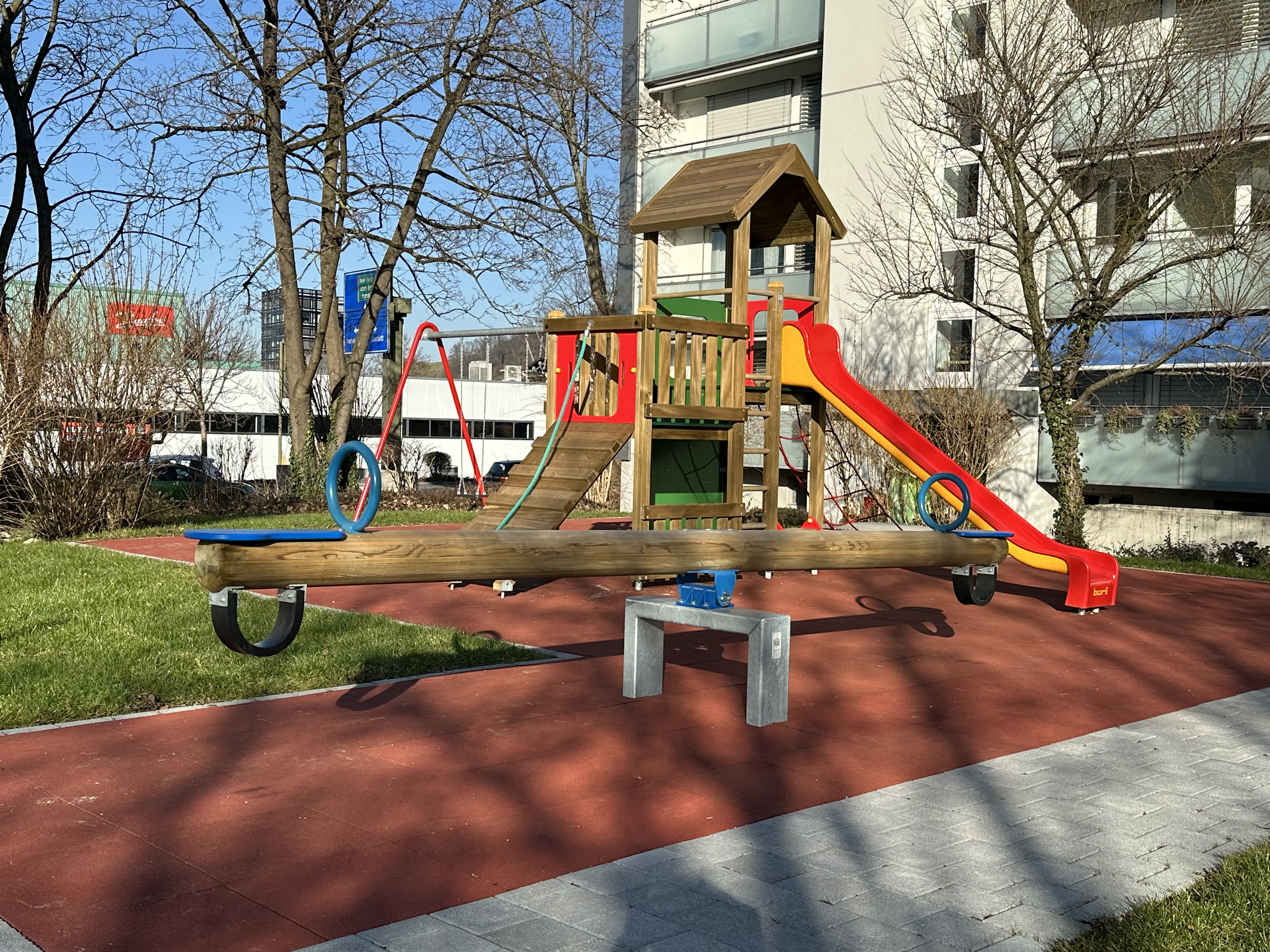 Moderner Spielplatz mit Rutsche und Gummibelag